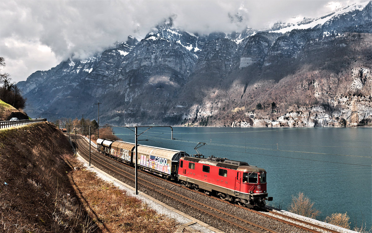 In Mols fährt die Re 4/4 III 430 350-9 mit einem Nahgüterzug dem Walensee entlang.Bild 23.3.2018