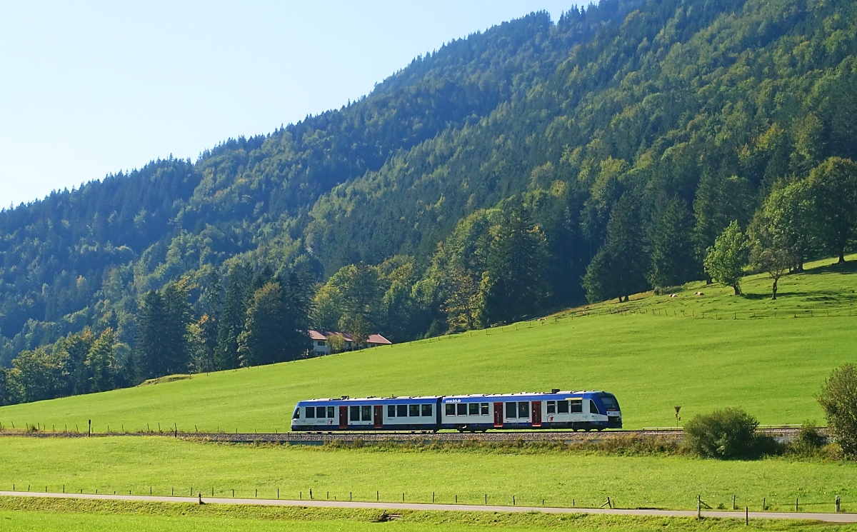 In der Nachmittagsssone des 04.09.2023 fährt ein unbekannter LINT 54 der Bayerischen Regiobahn bei Aurach von Bayrischzell nach München