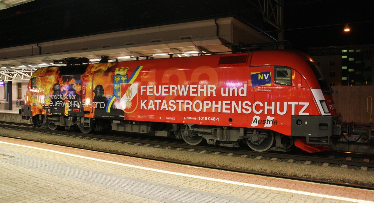 In der Nacht des 16.9.2015 steht die neue Werbe-Lok der ÖBB im Bahnhof Wörgl.
Die 1016 048-1  Niederösterreichischer Feuerwehrverband  mit Werbung für die Feuerwehr und den Katastrophenschutz. Unterstützt wird das Projekt von der Niederösterreichischen Versicherung. Der Zug ist auf dem Weg von Hall in Tirol über Kitzbühel nach Wels. In Wörgl kommen noch 2 Vorspannlok´s, eine 1144 und 1216 der ÖBB.