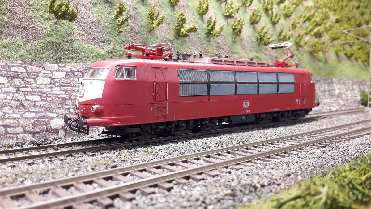 In den nächsten Bildern werde ich verschiedenste Versionen der E03 ( 103 ) in Harrstadt zeigen. Serienlok  in Orienrot  103 231-7
Kein Silbernes Dach mehr, keine Regenrinne, Pufferverkleidung, keine Schürze, 2 Lüfterreihen, langer Führerstand, Einholmstromabnehmer,  Modell Roco 43619,  DC nachdigitalisiert.