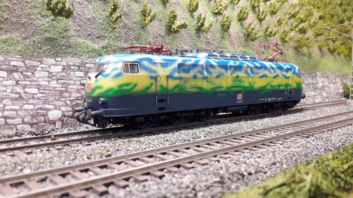 In den nächsten Bildern werde ich verschiedenste Versionen der E03 ( 103 ) in Harrstadt zeigen.  BR 103 220-0 . Diese Lok bekam Ihren Look mit Entstehung des Touristikzuges im Jahre 1995 ( Touristikzug fuhr von 1995 bis 2001 ). Im Jahre 2017 ( nach vorheriger langer Zeit in Eisenbahnmuseen ) wurde Sie nochmal aufwendig neu lackiert und steht seit 21.07.2021 ebenfalls in Koblenz Lützel. Das Modell selber entstand im Jahre 2012 durch eine Lackierung des Controllers (Chemnitz), da es zu diesem Zeitpunkt keine echtes Modell in der Form ( Keine Pufferverkleidung , keine Frontschürze ) gab. Grundmodell war ebenfalls die Roco Nr.
63741 , DC digital. Also mehr oder weniger eine Extraanfertigung.