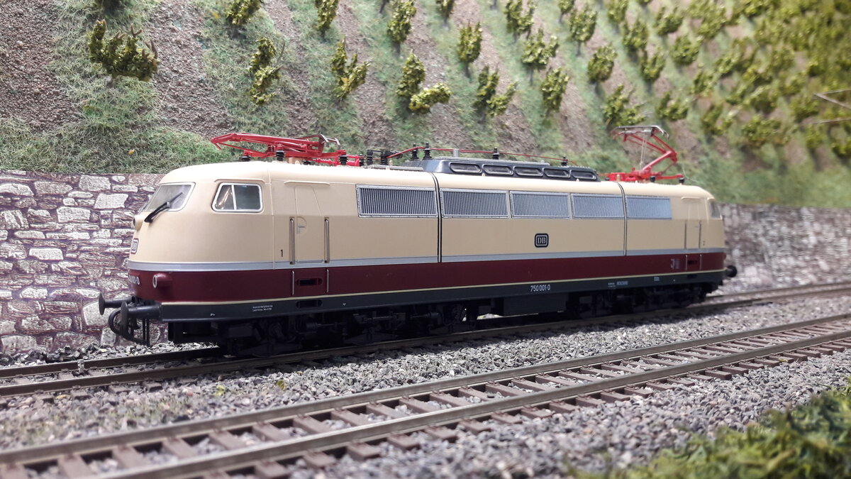 In den nächsten Bildern werde ich verschiedenste Versionen der E03 ( 103 ) in Harrstadt zeigen. Vorserie BR 103 001 als Dienstlok BR 750 001-0 , in der besonderen Version mit 2 verschiedenen DB Keksen, vorne in rot und seitlich der alte Keks. Auch wurde die Lok wie folgt, zum Ursprung, ihrer Frontschürze, den Pufferverkleidungen und der Regenrinne beraubt. 
Modell Roco 63746 DC digital