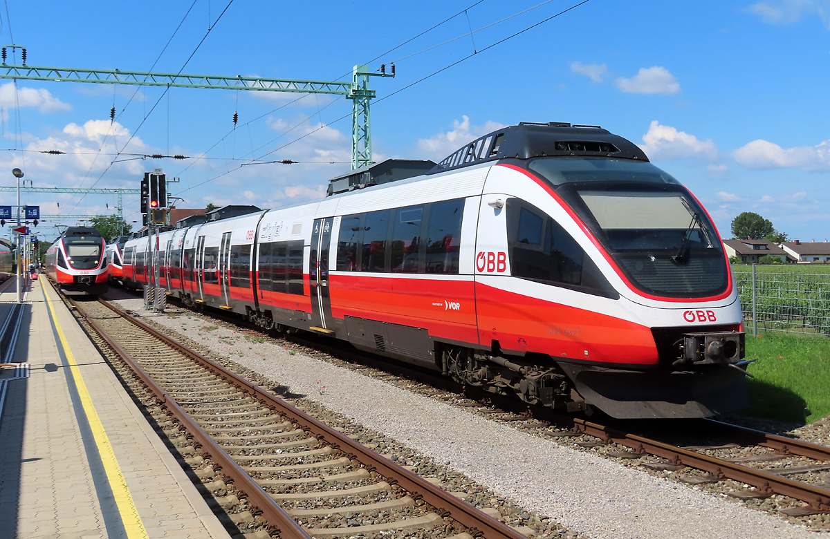 In Pamhagen ist der Regional-Express bereit für die Abfahrt Richtung Neusiedl am See, während rechts die leeren Triebzüge auf ihren nächsten Einsatz warten. Pamhagen, 17.6.2023