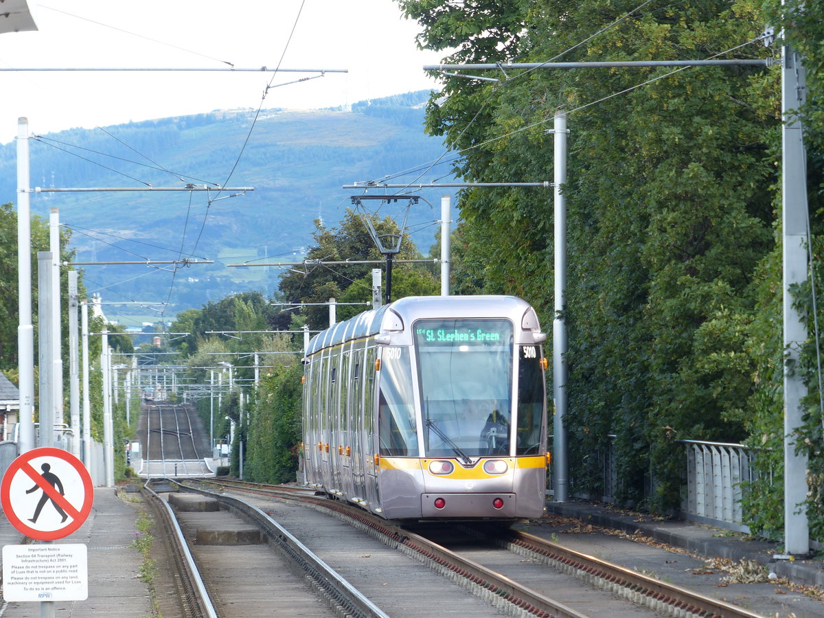 In Ranelagh fährt die LUAS-Straßenbahn auf eigenem Gleisbett, hier erfolgt ein Ebenenwechsel etwa aus Dachhöhe herunter auf die normale Ebene. Die grüne Linie ist eine von zwei Straßenbahnlinien, die im Jahr 2004 ihren Betrieb aufnahmen. Auf den alten Bahngleisen werden Geschwindigkeiten bis zu 70 km/h gefahren. Diese Bahn fährt gerade stadteinwärts zu einer provisorischen Endhaltestelle, die durch Streckenbaumaßnahmen (Verknüpfung beider Linien) nötig wurde. 5.8.2017, Ranelagh