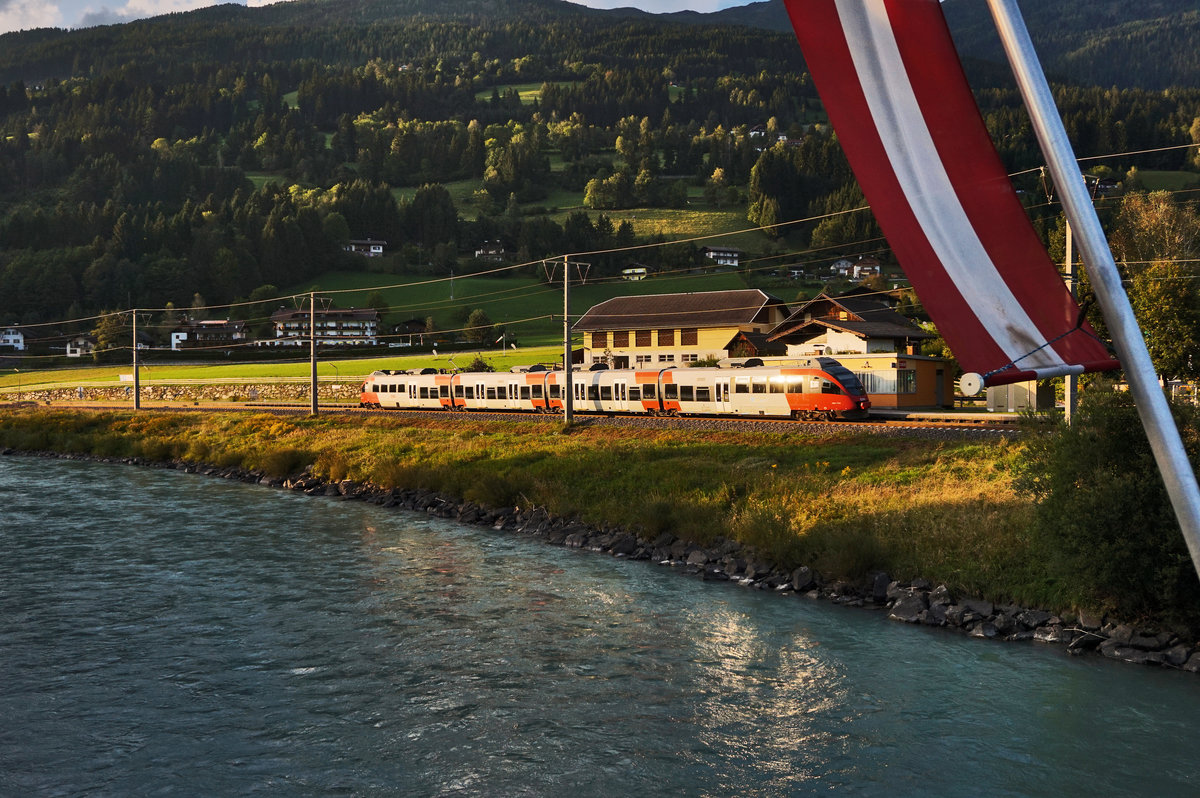 In rot-weiß-rot, passend zur österreichischen Flagge, präsentiert sich der von der Abendsonne angestrahlte 4024 113-5  Unser Land .
Unterwegs war die Garnitur als S1 4262 (Lienz - Villach Hbf).
Aufgenommen am 2.9.2016 bei der Haltestelle Berg im Drautal.