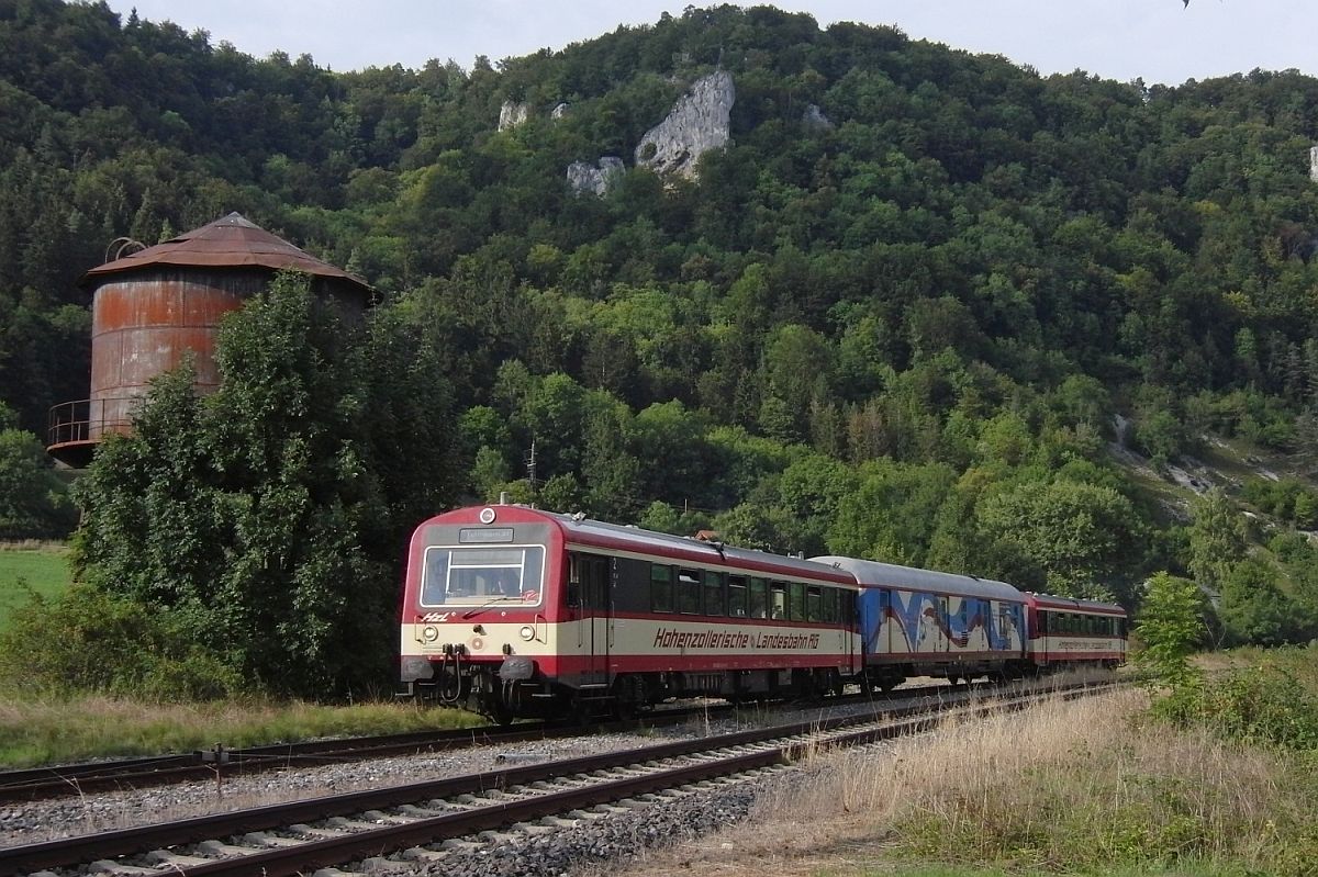 In den Sommermonaten ist an Wochenenden der Naturpark-Express, gebildet aus zwei Triebwagen der Hohenzollerischen Landesbahn und einem Fahrradtransportwagen, zwischen Sigmaringen und Tuttlingen unterwegs. Am 07.09.2013 wurde HzL 88109 auf der Fahrt nach Tuttlingen am alten, in der Zwischenzeit leicht zugewachsenen Wasserturm in Hausen im Tal fotografiert.