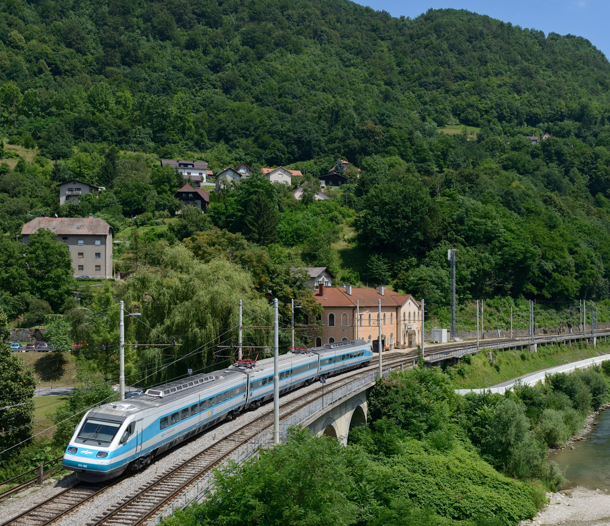 In steilem Winkel neigt sich der kleine slowenische Pendolino 310 002 als IC 18 (Ljubljana-Maribor) in die engen Bögen des Save-Tales, fotografiert am 20.Juni 2018 in Hrastnik.