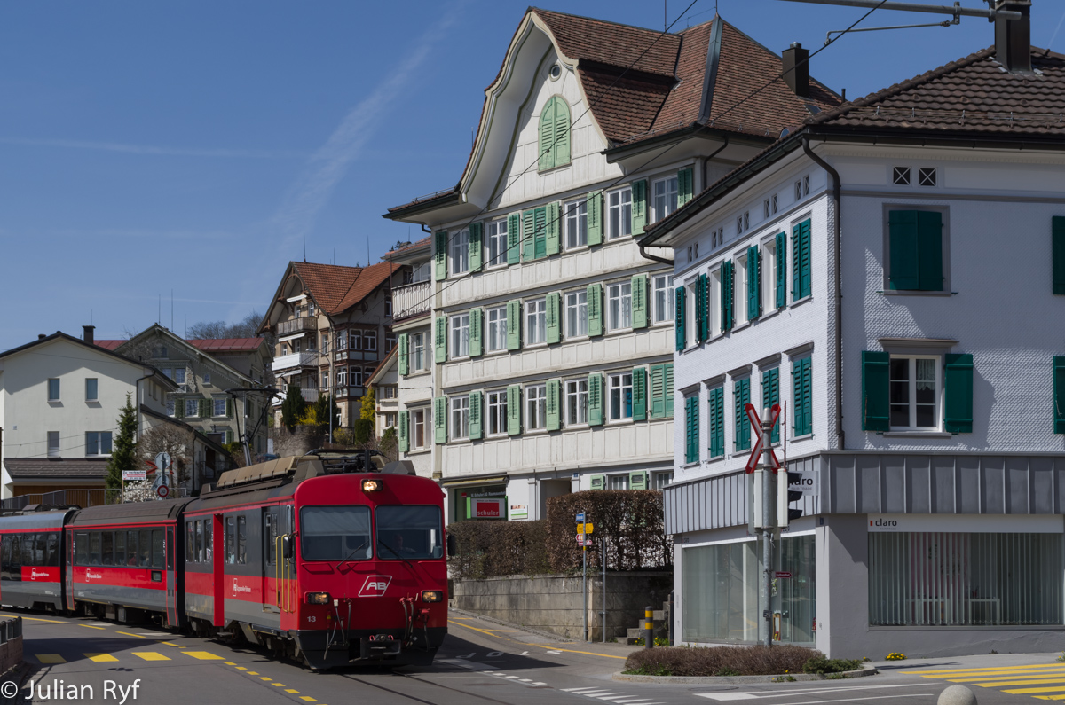 In Teufen fahren die Appenzeller Bahnen mitten durch das Dorf. Auch hier stehen in den nächsten Jahren grössere Veränderungen an. Die Gleise sollen auf Doppelspur ausgebaut werden und der Zug sich somit in beide Fahrtrichtungen mit dem Verkehr bewegen. Ab Inbetriebnahme der Durchmesserlinie werden an Stelle der bisherigen Kompositionen neue Stadtbahnzüge vom Typ Stadler Tango eingesetzt. Der BDeh 4/4 13 befindet sich am 14. April 2015 zwischen der Haltestelle Stofel und dem Bahnhof Teufen.