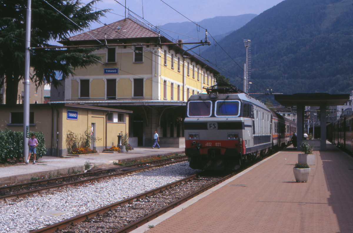 In Tirano trifft das schmalspurige Netz der Rhätischen Bahn auf das Netz der italienischen Staatsbahn FS. Hier steht die E632 021 mit einem Diretto (Eilzug) nach Milano Centrale bereit zur Fahrt durch das Veltlin und entlang des Lago di Como in die norditalienische Metropole.
Tirano, 29. August 1990; Canon A1, Canoscan, Gimp