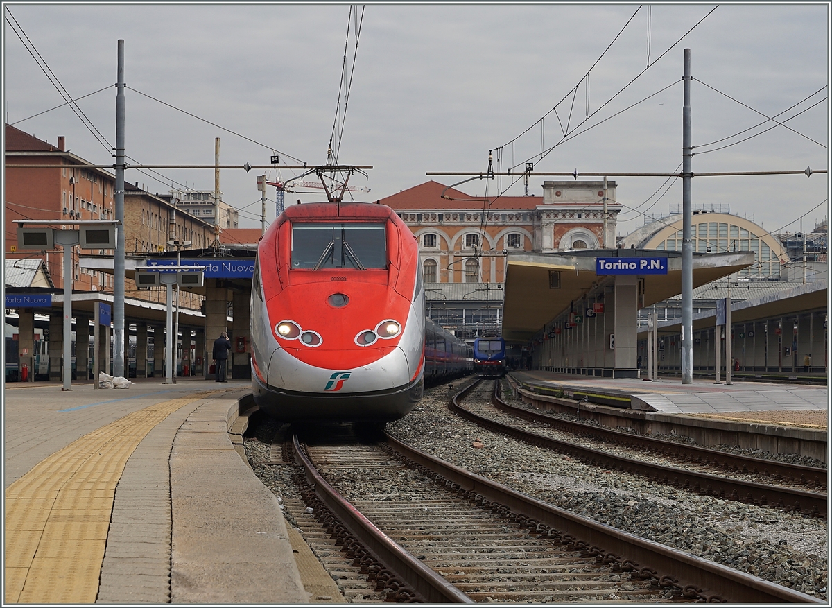 In Torino Porta Nuova wartet ein ETR 500 als Frecciarossa 9623 auf die Abfahrt Richtung Rom 
Im Hintergrund, rechts im Bild die Bahnhofshalle, welche wie jene in Zürich, die Züge aufnahm, bevor sie zu klein wurde und die wesentlich erweiterte Bahnhofsanlage  vor  dem Bahnhof dem Betriebe aufnahm. 
10. März 2016