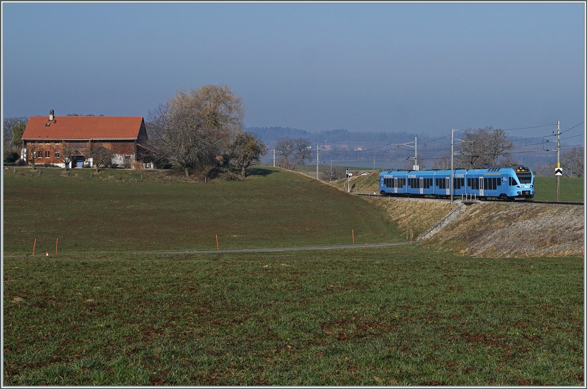 In weiten Kurven windet sich das Trasse der Strecken von Romont nach Vuisternens-devant- Romont, um die gut achzig Höhenmeter zu überwinden. Der im sehr gefälligen Werbeanstrich der  Groupe Grisoni  gehaltene TPF RABe 527 198 hat die Steigung fast geschafft und erreicht in Kürze den Bahnhof  Vuisternas-devant-Romont, welcher jedoch wie alle Station zwischen Romont und Bulle nur noch dienstlichen Zwecken dienen. 

1. März 2021