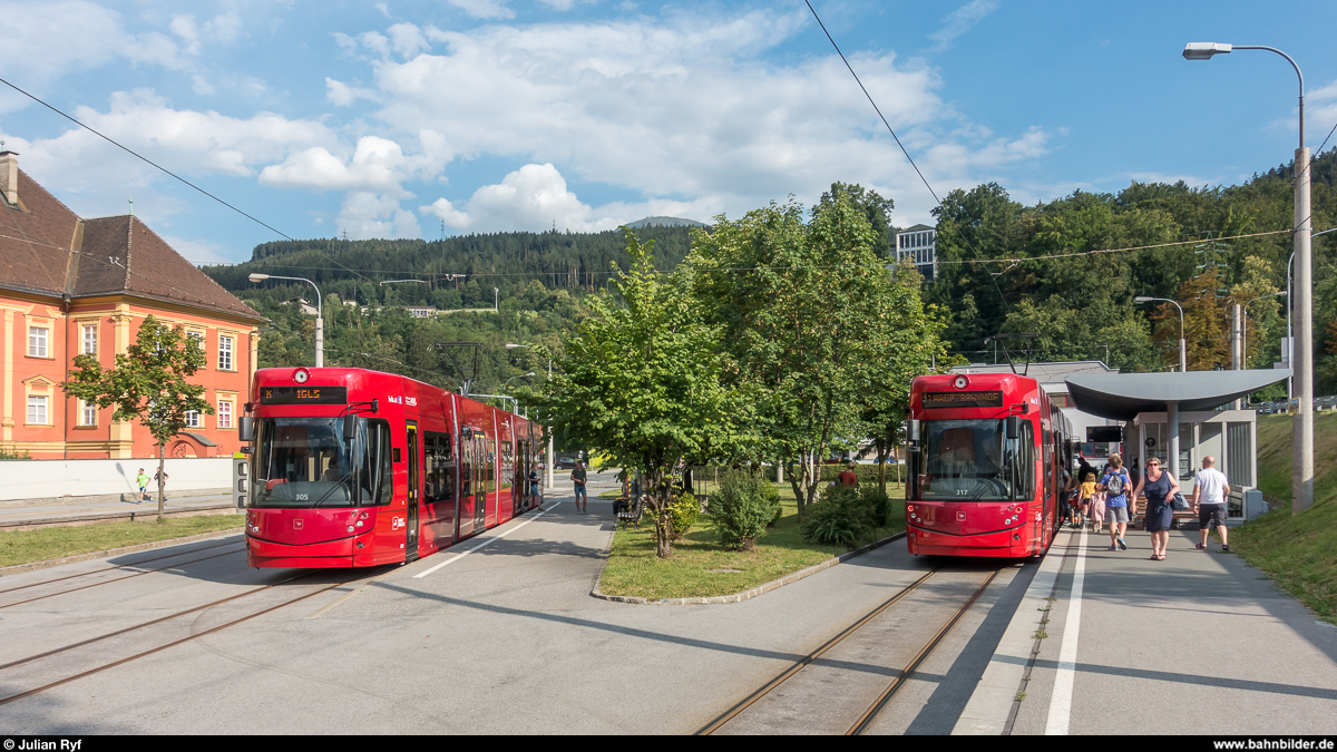 Innsbrucker Mittelgebirgsbahn/Tramlinie 6: Flexity 305 an der Endhaltestelle Bergisel, welche sich innerhalb der Wendeschleife der Linie 1 befindet. Flexity 317 wartet auf der Linie 1 gerade auf die Abfahrt zum Innsbrucker Hauptbahnhof.