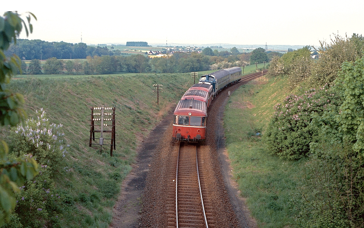 Interessant ist auch diese Zugbildung mit Lok in der Mitte, bei der der Schienenbus einem geschobenen Wendezug angehängt wurde (bei Dorheim, 16.5.1985).
