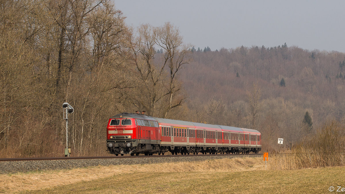 IRE 4209 mit 218 496-8 am 15.03.2015 im Schussentobel zwischen Aulendorf und Mochenwangen, am Einfahrvorsignal des Bf Mochenwangen. Nächster Halt des Zuges: Ravensburg.