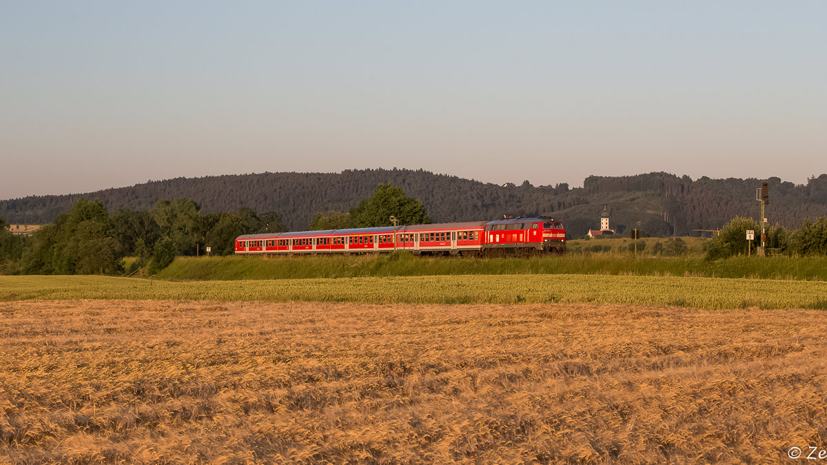 IRE 4215 gezogen von 218 427-3 am 01.07.2015 bei Winterstettenstadt. Im Hintergrund ist der Kirchturm der Gemeinde Unteressendorf zu sehen.