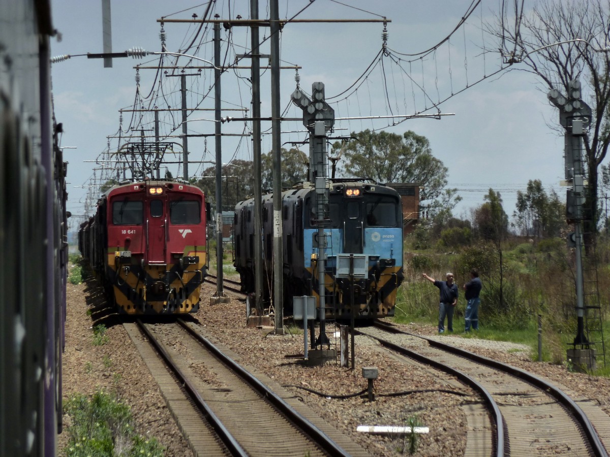 Irgendwo zwischen Klerksdorp und Johannesburg überholt der Shosholoza Meyl einen Güterzug sowie einige Prasa E-Loks. Aufgenommen am 20.11.2014.