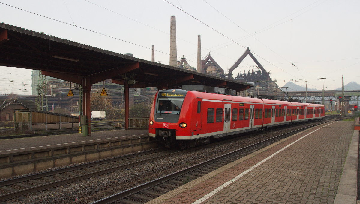 Ivie hatte einen Arzttermin und ich bin inzwischen zum Völklinger Bahnhof geschlendert. Kurz vor dem Regen kam 425 088 als RB Merzig - Kaiserslautern nach Völklingen, im Hintergrund das UNESCO Weltkulturerbe Völklinger Hütte. Bahnstrecke 3230 Saarbrücken - Karthaus am 15.12.2015
