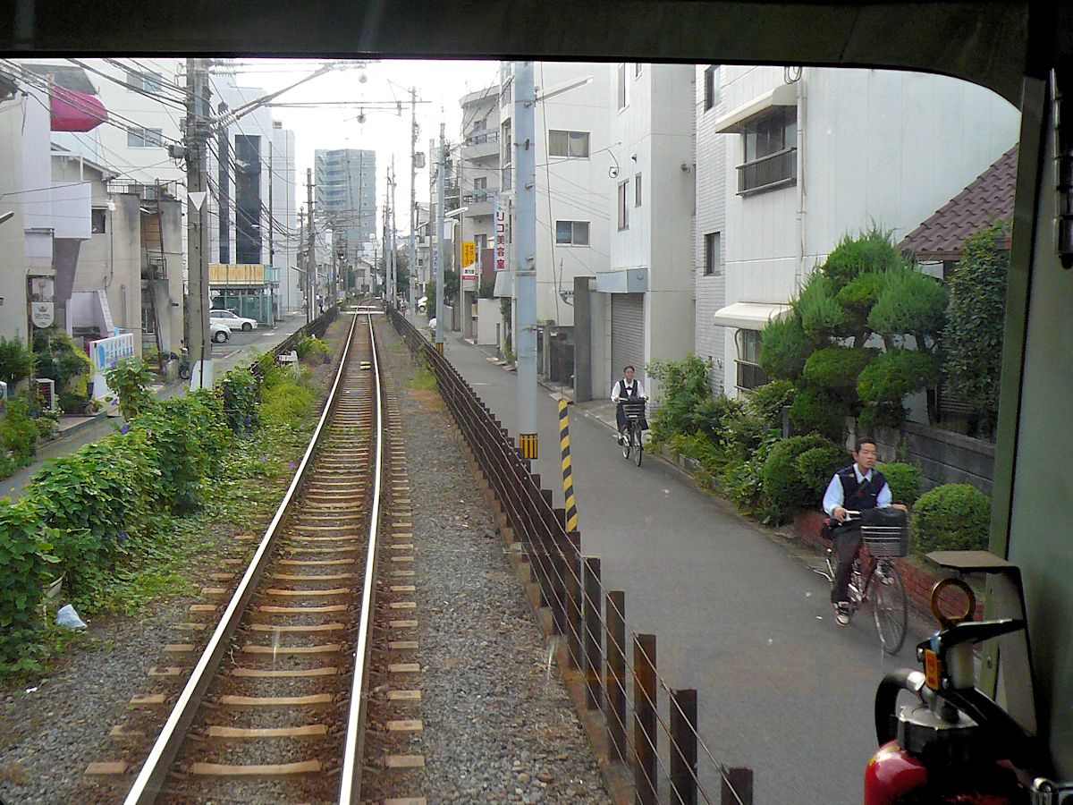 Iyo-Bahn: Bei der Ausfahrt aus Matsuyama auf der Yokogawara-Linie im Zug 3502 geht es zuerst durch die typische Provinzstadt Richtung Osten, 18.September 2009.  