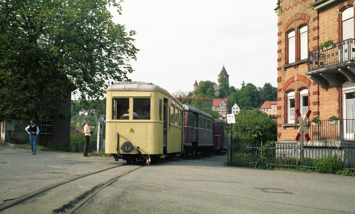 Jagsttalbahn__Triebwagen-Zug bei der Ausfahrt aus dem Bf Möckmühl mit Götzenburg im Hintergrund.__17-05-1986