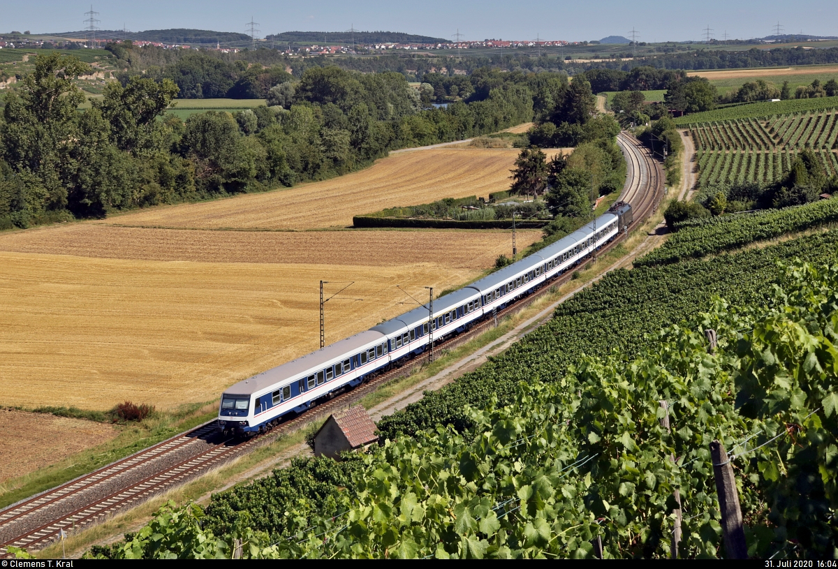 Jahresrückblick 2020 #3

Aufgrund von Lieferverzögerungen der Bombardier Talent 2 wurde für die Abellio Rail Baden-Württemberg GmbH ab dem 14.6.2020 ein umfangreiches Ersatzkonzept auf den gewonnenen Linien RB 18, RE 10a, RE 10b und IRE 6 gefahren. Dafür wurden unterschiedliche Unternehmen beauftragt.
Mein persönlicher Favorit war die stets gepflegt wirkende TRI-Garnitur, mit der ich auch mehrmals gefahren bin. An einem sehr heißen Sommernachmittag fährt dieser Zug an den Weinbergen bei Nordheim (Württemberg) entlang.
Er besteht aus dem n-Steuerwagen Bnrdzf 483.0 (50 80 80-35 141-6 D-TRAIN), vier weiteren n-Wagen sowie der Lok 182 597-5 (Siemens ES64U2-097), gemietet von der Mitsui Rail Capital Europe GmbH (MRCE).

🧰 TRI Train Rental GmbH
🚝 RE 95905 (RE10a) Heilbronn Hbf–Tübingen Hbf
🚩 Bahnstrecke Stuttgart–Würzburg (Frankenbahn | KBS 780)
🕓 31.7.2020 | 16:04 Uhr