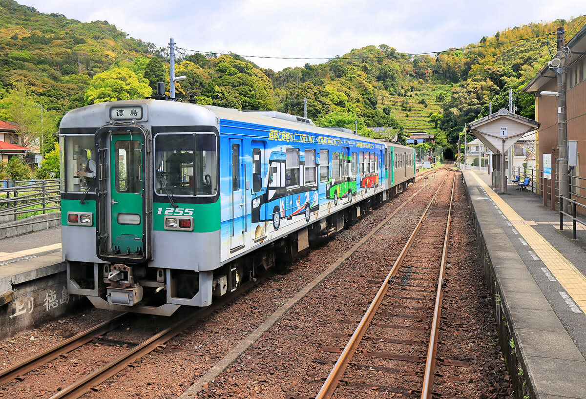Japan, JR Shikoku: Werbung für die Schiene-/Strassefahrzeuge der entsprechend umgebauten Asa Kaigan Bahn. Ein Zweiwagenzug 1231 - 1255 kreuzt auf der Mugi Linie in Yuki, ganz im Südosten der Insel Shikoku. 17.April 2023  