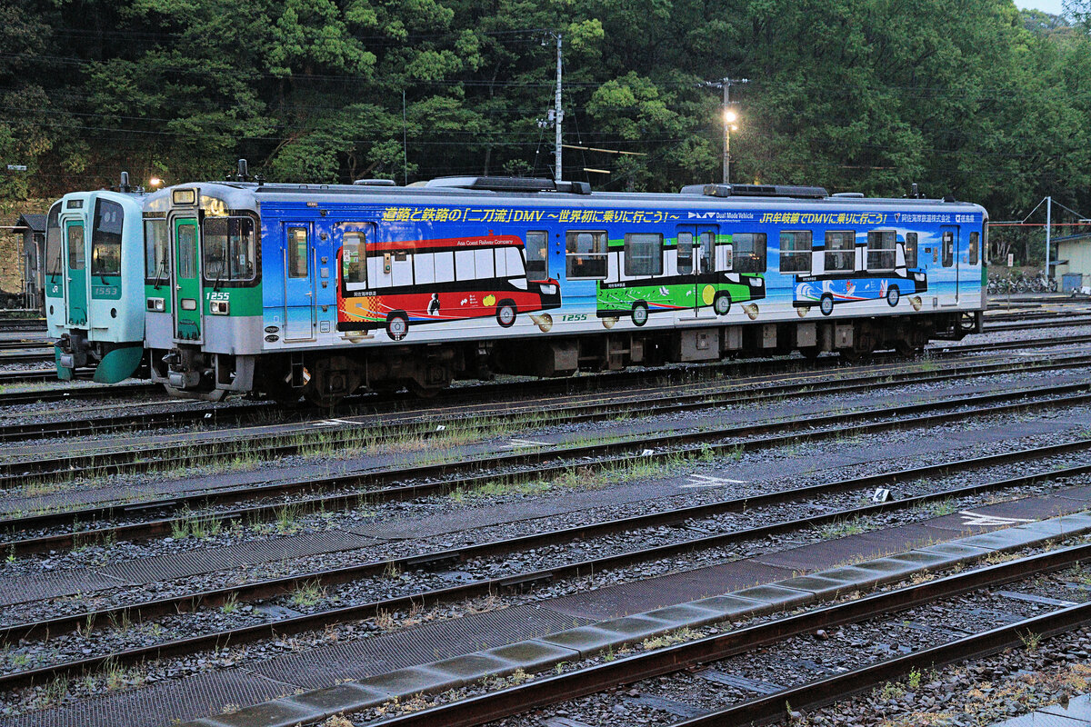 Japan, JR Shikoku: Werbung für die Schiene-/Strassefahrzeuge der entsprechend umgebauten Asa Kaigan Bahn im äussersten Südosten der Insel Shikoku. Diese Bahn schliesst an die Mugi Linie von JR Shikoku an, auf der der abgebildete Triebwagen verkehrt. Der abgebildete Triebwagen gehört zu einer Serie von 56 diesel-hydraulischen Wagen aus den Jahren 1990-1997 (Nummern 1001-1056, 18 Wagen umgebaut mit 1200er Nummern). Wagen 1255, Tokushima, 16.April 2023   