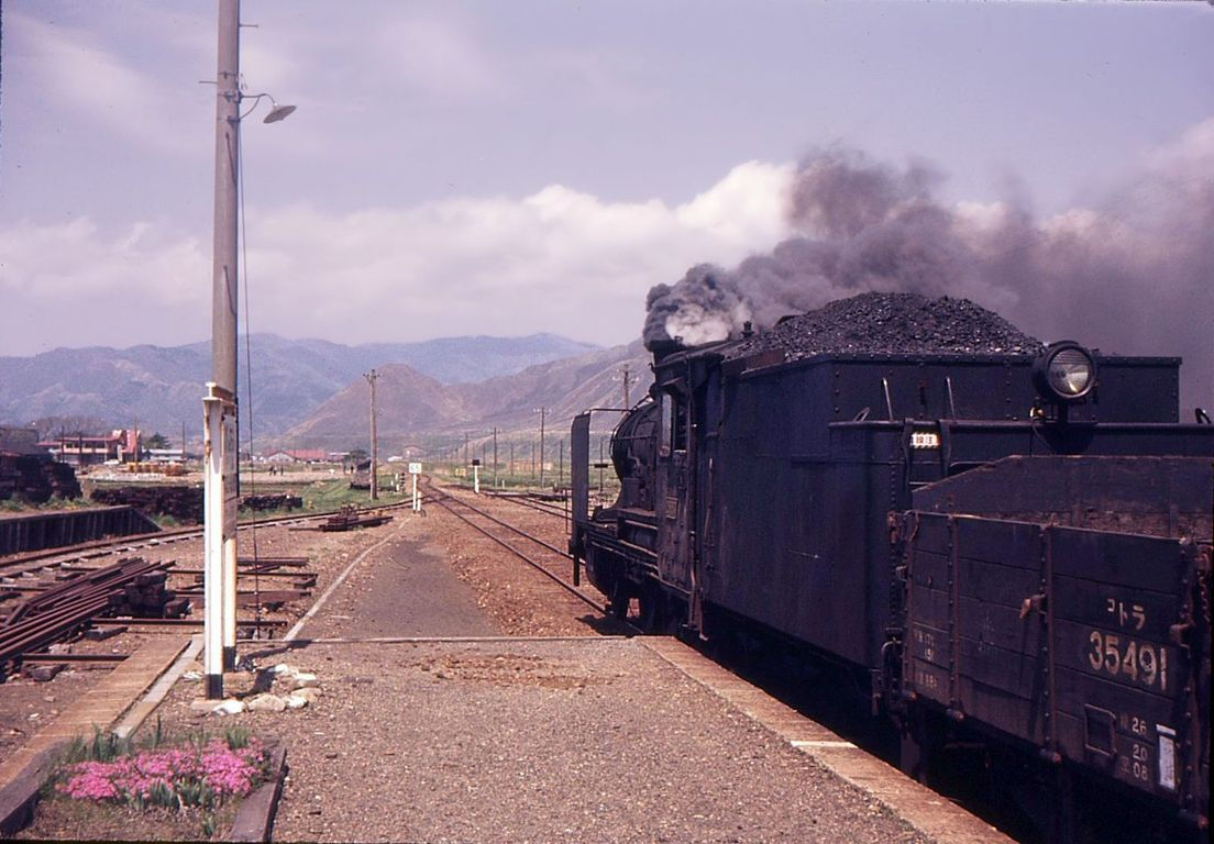 Japanische Dampfloks Serie 8620: Der andere Ort, wo diese Loks noch im Einsatz standen, war die einsame äusserste Nordwestküste der japanischen Hauptinsel. Hier steht Lok 2-8683 mit ihrem gemischten Personen-/Güterzug in Higashi Hachimori in einer kaum bevölkerten, kalten Gegend. 3.Mai 1972.   