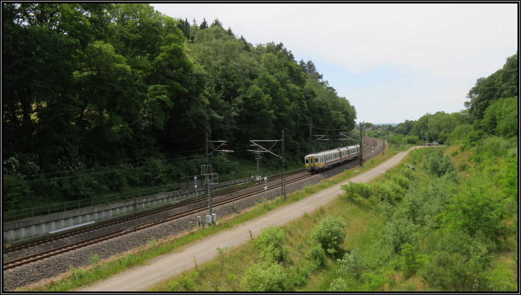 Ja,unsere lieben Nachbarn! Auch im Preußwald unweit von Aachen gilt Linksverkehr auf der Bahnlinie nach Belgien,wie hier zu sehen. Ein Triebwagen nähert sich gerade den Buschtunnel und wird in wenigen Minuten den Aachener Hauptbahnhof erreichen.
Szenario vom 17.06.2015.