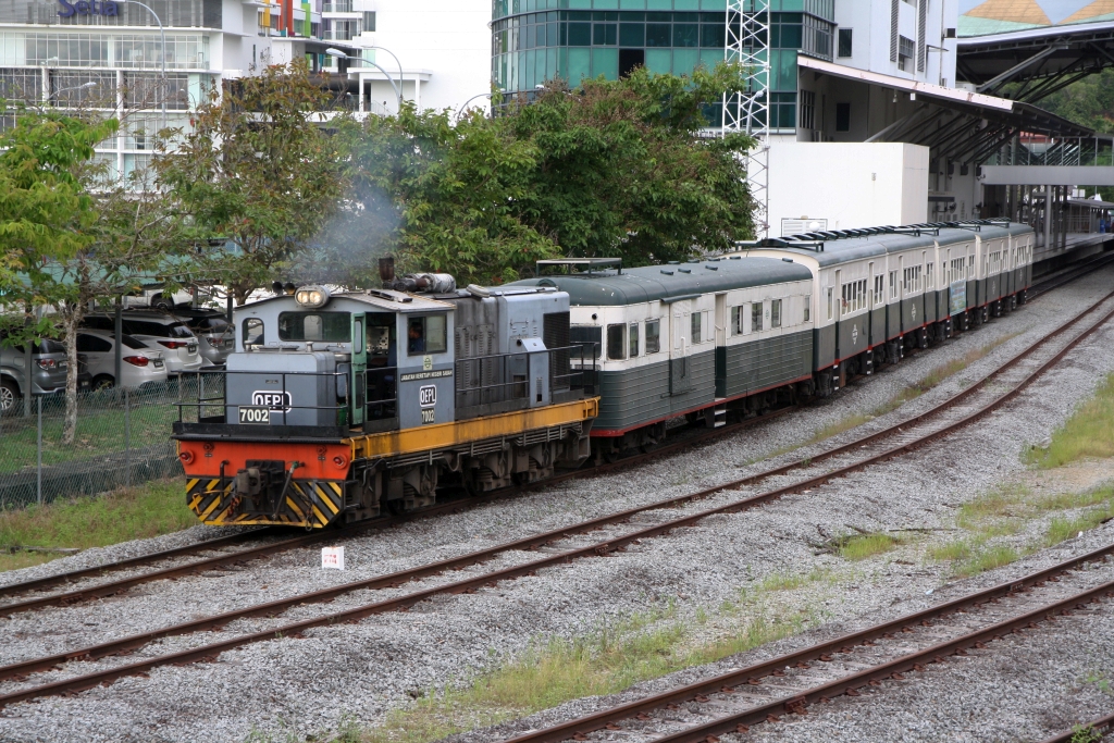 JKNS 7002 (Hersteller: OEPL, Ovis Equipments Private Ltd., Indien, Type: YHD 800 48) fährt am 08.Februar 2025 mit dem nur an Samstag verkehrenden Touristenzug  TRAIN TO MUARA SUNGAI BENONI  aus der Stesen Tanjung Aru.