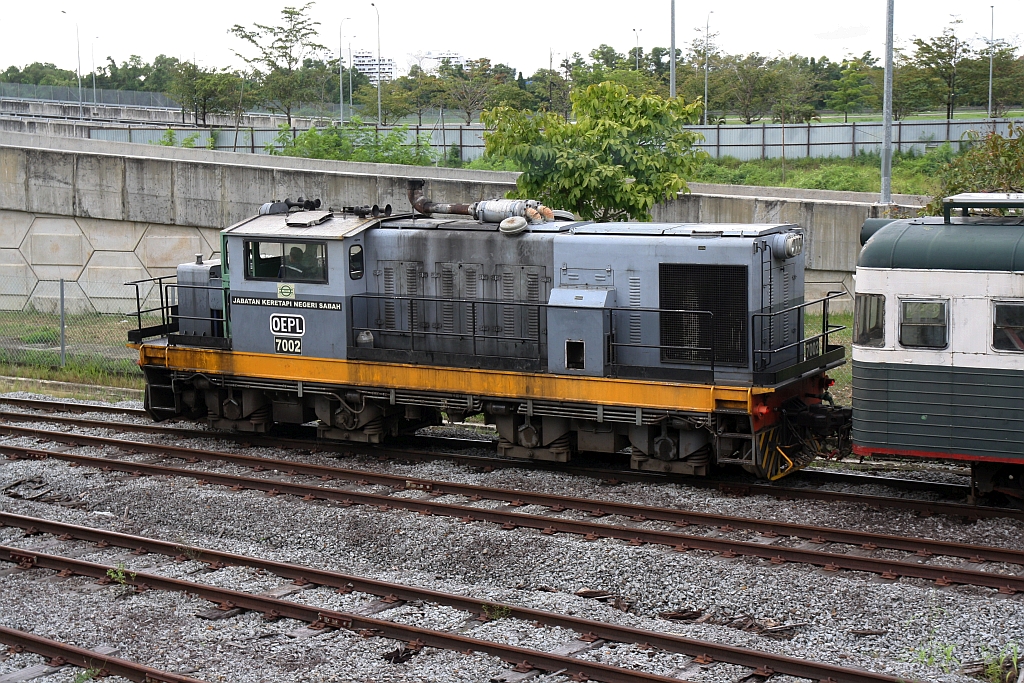 JKNS 7002 (Hersteller: OEPL, Ovis Equipments Private Ltd., Indien, Type: YHD 800 48) am 08.Februar 2025 vor dem nur an Samstag verkehrenden Touristenzug  TRAIN TO MUARA SUNGAI BENONI  bei der Ausfahrt aus der Stesen Tanjung Aru.