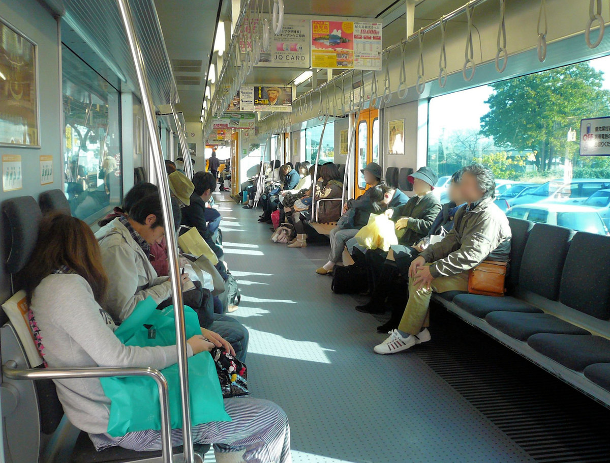 JR Kyûshû Serie 815. Blick in den Innenraum des Zuges 815-8. Die storenlosen grossen Fenster sind grün getönt, rechts vorne an der Wand erkennt man knapp den Hinweis (OFF), dass es in japanischen Zügen verboten ist, Gespräche auf dem Handy zu führen. 1.Dezember 2010  