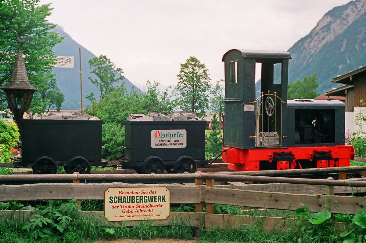 Juni 1991, Österreich, am Achensee steht diese Jung-Lok mit zwei Loren einer Grubenbahn und wirbt für den Besuch der Tiroler Steinölwerke. Saß der Lokführer hier im  Goldenen Käfig ?