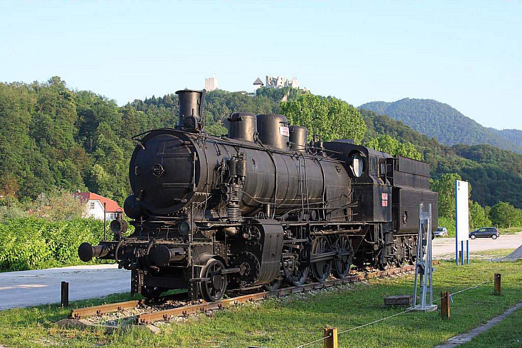 Jz Schlepptender Dampflok 25002 wurde am Bahnhof in Celje als Denkmal aufgestellt.
Die Lok steht auf der dem Bahnhof gegenüber liegenden Seite. Am 25.05.2011 machte 
ich die Aufnahme mit der im Hintergrund befindlichen Burg in Celje.