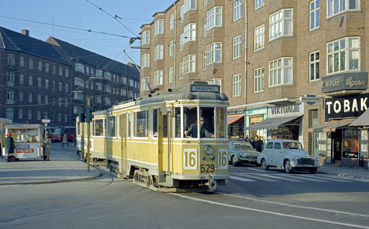 København / Kopenhagen Københavns Sporveje SL 16 (Tw 529 + Bw 15xx) Valby, Toftegårds Plads am 26. März 1969. - Auch am Toftegårds Plads gab es damals die Möglichkeit, einen kleinen Imbiss zu genießen; den 'Pølsevogn', dh. den Wurstwagen, der zum Kopenhagener Stadtbild gehörte, fand man auch hier (links im Bild). - Scan eines Farbnegativs. Film: Kodak Kodacolor X.