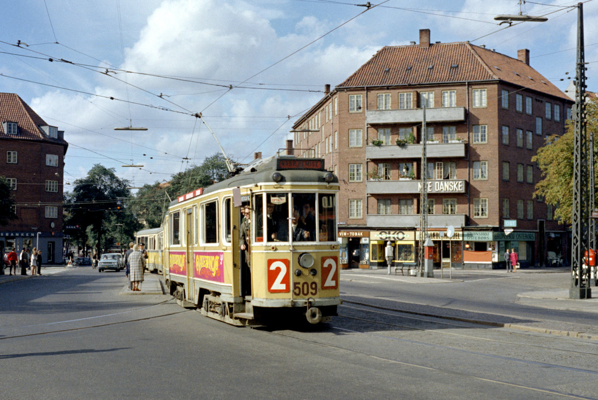 København / Kopenhagen Københavns Sporveje SL 2 (Tw 509 + Bw 1503) Brønshøj, Frederikssundsvej / Brønshøj Torv am 28. September 1969. - Der offizielle Teil der  Sonderfahrt für Mitglieder der Sporvejshistorisk Selskab (: der Dänischen Gesellschaft für Straßenbahngeschichte) ist vorbei - die Drehgestellgarnitur bestehend aus dem Tw 509 und dem Bw 1503 kehrt zum Betriebsbahnhof Nørrebro zurück. - Das Bild zeigt außer der Straßenbahn rechts ein paar andere damals übliche  Straßenelemente : einen Telefonständer des Kopenhagener Taxiunternehmens  Taxa , eine städtische Straßenbank, einen Feuermelder und einen roten Briefkasten. - Scan eines Farbnegativs. Film: Kodak Kodacolor X.