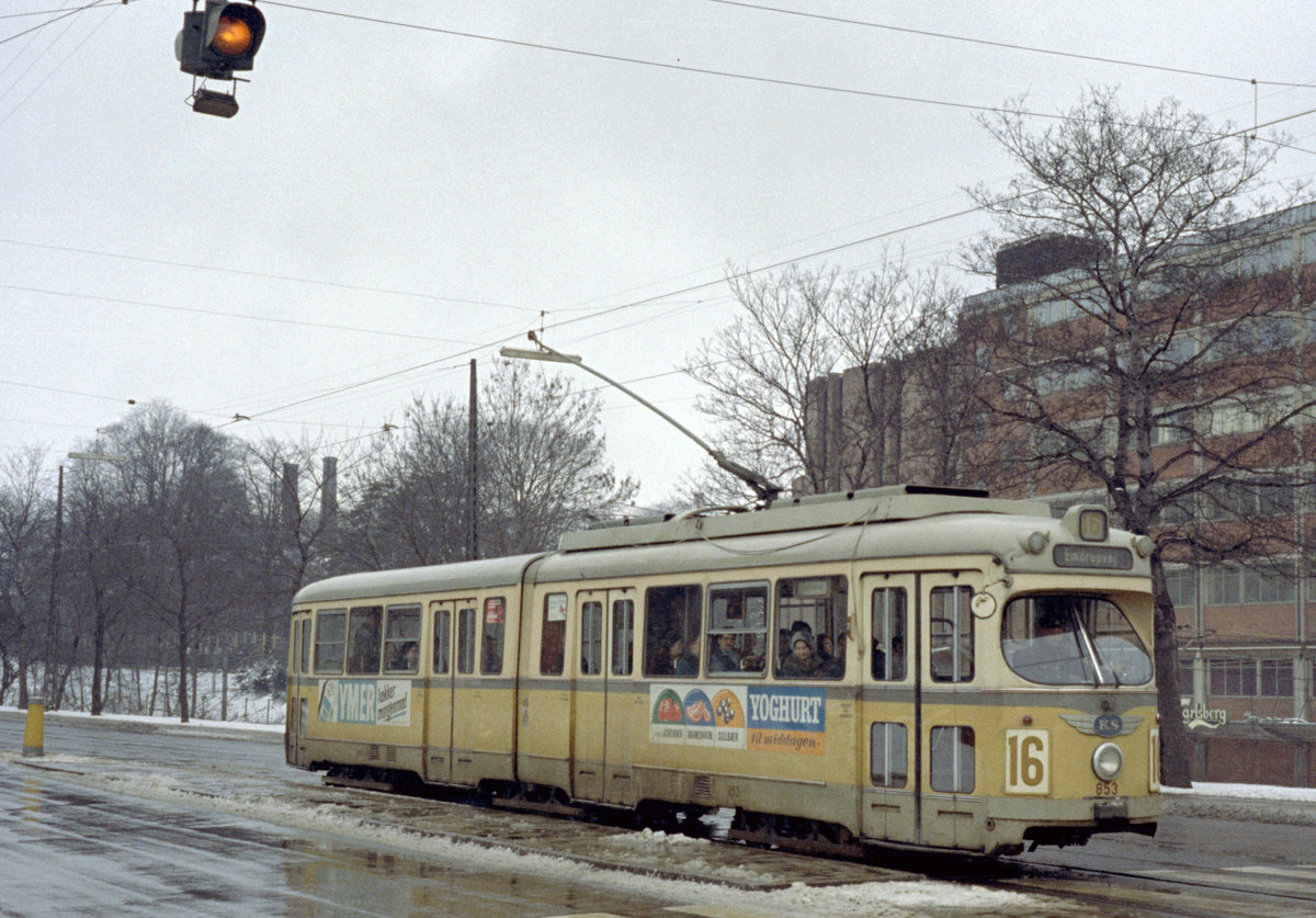 København / Kopenhagen Københavns Sporveje SL 16 (DÜWAG/Kiepe-GT6 853) Vigerslev Allé / Vestre Kirkegärds Allé am 5. April 1970. - Im Hintergrund befindet sich die Brauerei Carlsberg. Seit 2008 werden die Erzeugnisse der Brauerei - mit Ausnahme von den Erzeugnissen der  Hausbrauerei Jacobsen  - in der Stadt Fredericia in Jütland hergestellt. Statt der meisten Anlagen zur Herstellung von den verschiedennen Biersorten und Erfrischungsgetränken gibt es jetzt auf einem Teil der Grundstücke der Brauerei eine neue Siedlung, die  Carlsberg-Byen  (: die  Carlsberg-Stadt ). - Scan eines Farbnegativs. Film: Kodak Kodacolor.