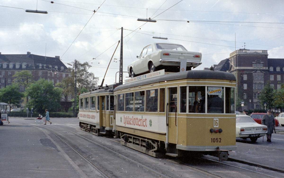 København / Kopenhagen Københavns Sporveje: Am 28. September 1967 fuhr als Werbung für das  Lykke-Lotto  der Wohltätigkeitsstiftung  Vanførefonden  ein Zug bestehend aus dem Triebwagen 516 und dem Beiwagen 1052 als E-Wagen auf der SL 16. Auf dem Bild hält der Zug, der in Richtung Enghave Plads fährt, in der Nørre Voldgade. - Der Hauptgewinn im Lotto war ein Ford (Taunus) 17M. - Scan von einem Farbnegativ. Film: Kodacolor X. Kamera: Konica EE-matic.
