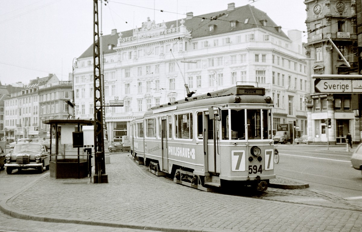 København / Kopenhagen Københavns Sporveje SL 7 (Tw 594 + Bw 15xx) Kongens Nytorv im Oktober 1967. Links von der Straßenbahnhaltestelle befand sich ein Taxistandplatz; vor dem Wartehäuschen sieht man einen  Telefonschrank  der Taxifirma  TAXA 3x35 . Im Hintergrund ist das Kopenhagener Luxushotel  Hotel d'Angleterre  zu sehen. - Scan von einem S/W-Negativ. Film: Ilford FP 3. Kamera: Konica EE-matic.
