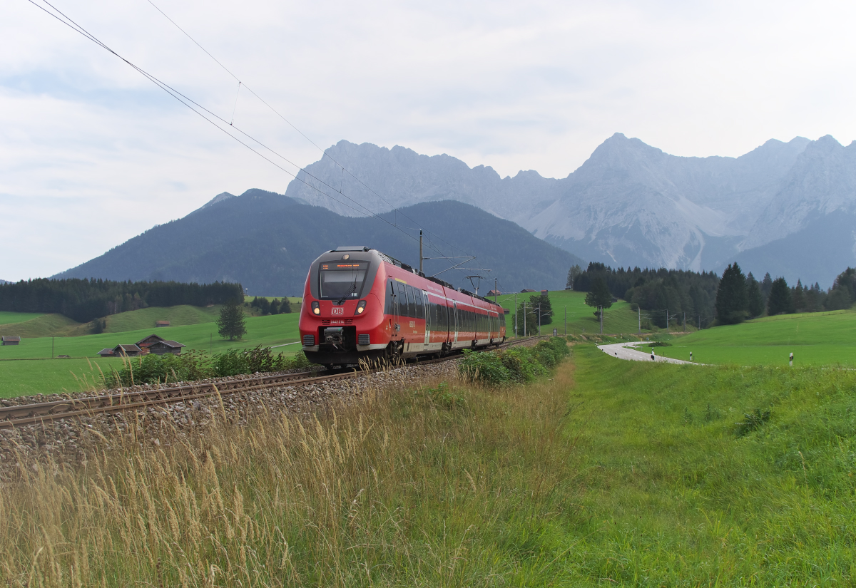 Karwendel Panorama: 2442 214 rollt gerade die Schmalenseehöhe zwischen Mittenwald und Klais hinab. Gleich passiert die RB nach München das Einfahrvorsignal von Klais. Bahnstrecke 5504 Müchen - Mittenwald Grenze beim Landhaus Wackerl am 15.09.2016 