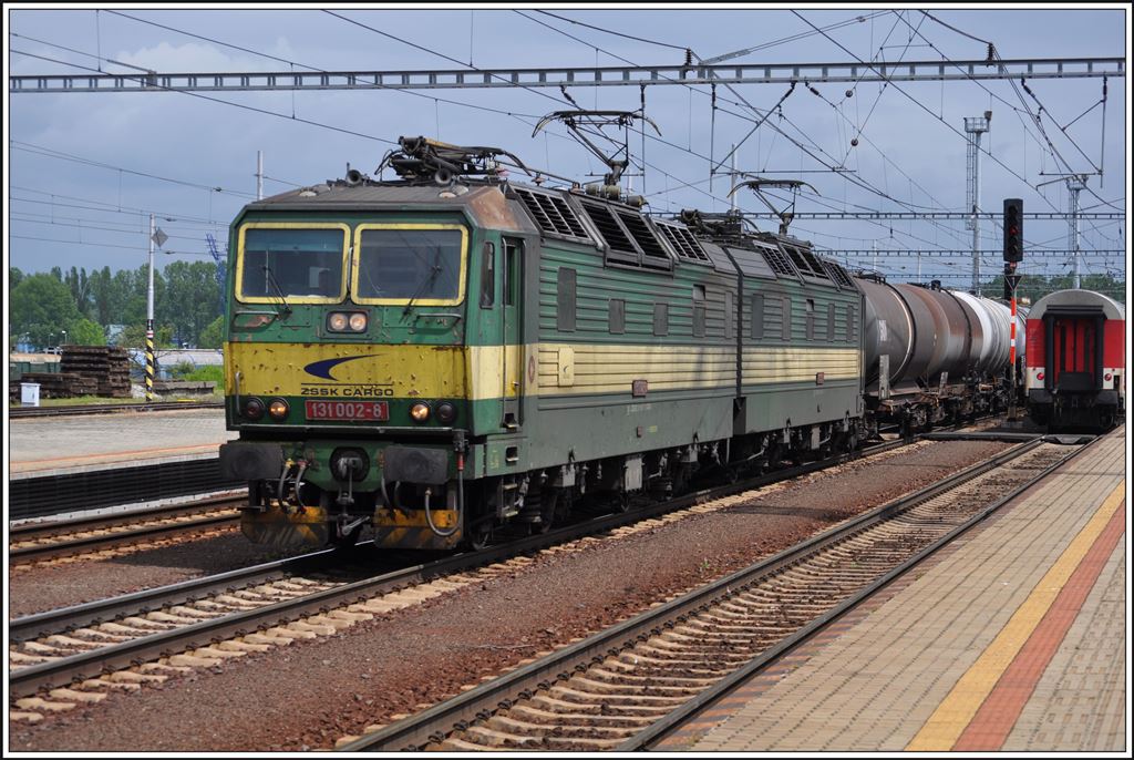 Kaum ist der IC503 weg kommt aus der Gegenrichtung ein langer Güterzug mit der Doppellok 131 002-8 an der Spitze und 183 006-6 als Schublok am Zugschluss. Poprad-Tatry (03.06.2014)
