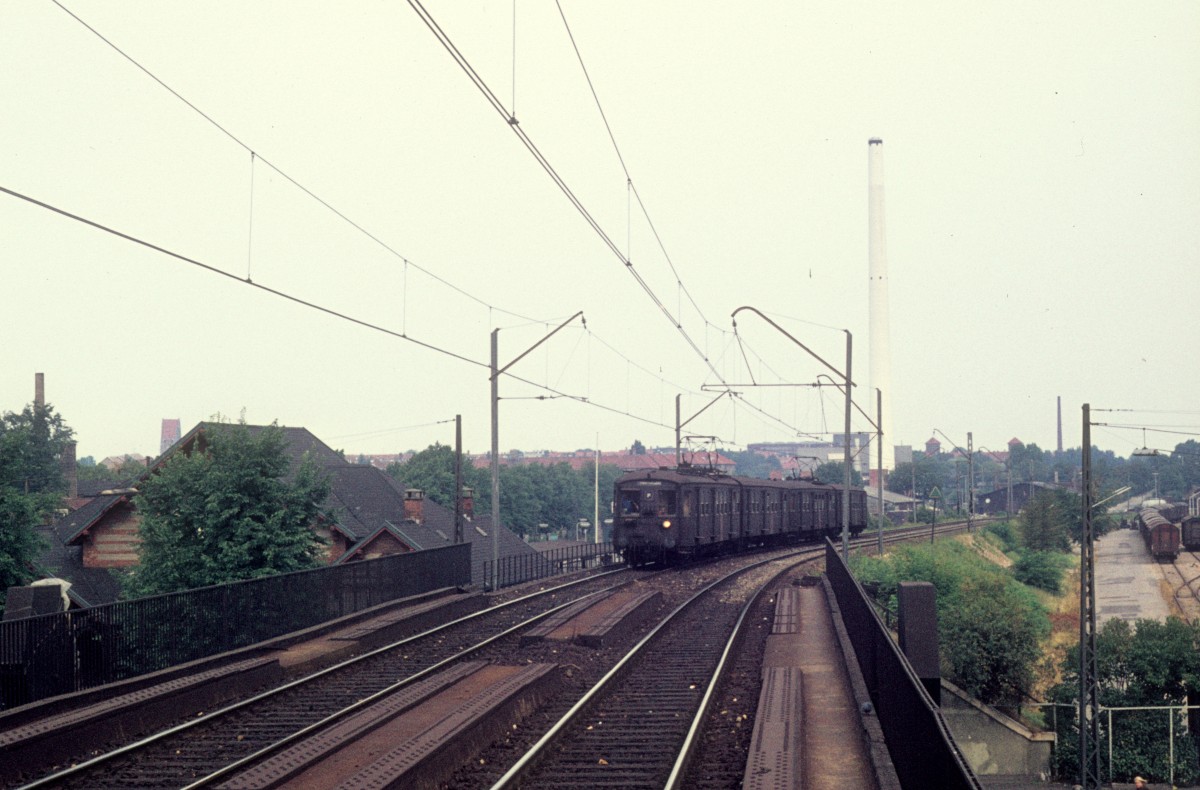 Kbenhavn / Kopenhagen DSB S-Bahn im August 1975: Ein Zug der Linie F nhert sich dem S-Bahnhof Nrrebro. Der Zug fhrt in Richtung Frederiksberg. - Das Gebude, das man links im Bild ahnen kann, gehrte zum DSB-Bahnhof Kbenhavn L - hier endeten die Zge, die nach Farum fuhren. - Rechts lag damals der Gterbahnhof Nrrebro.
