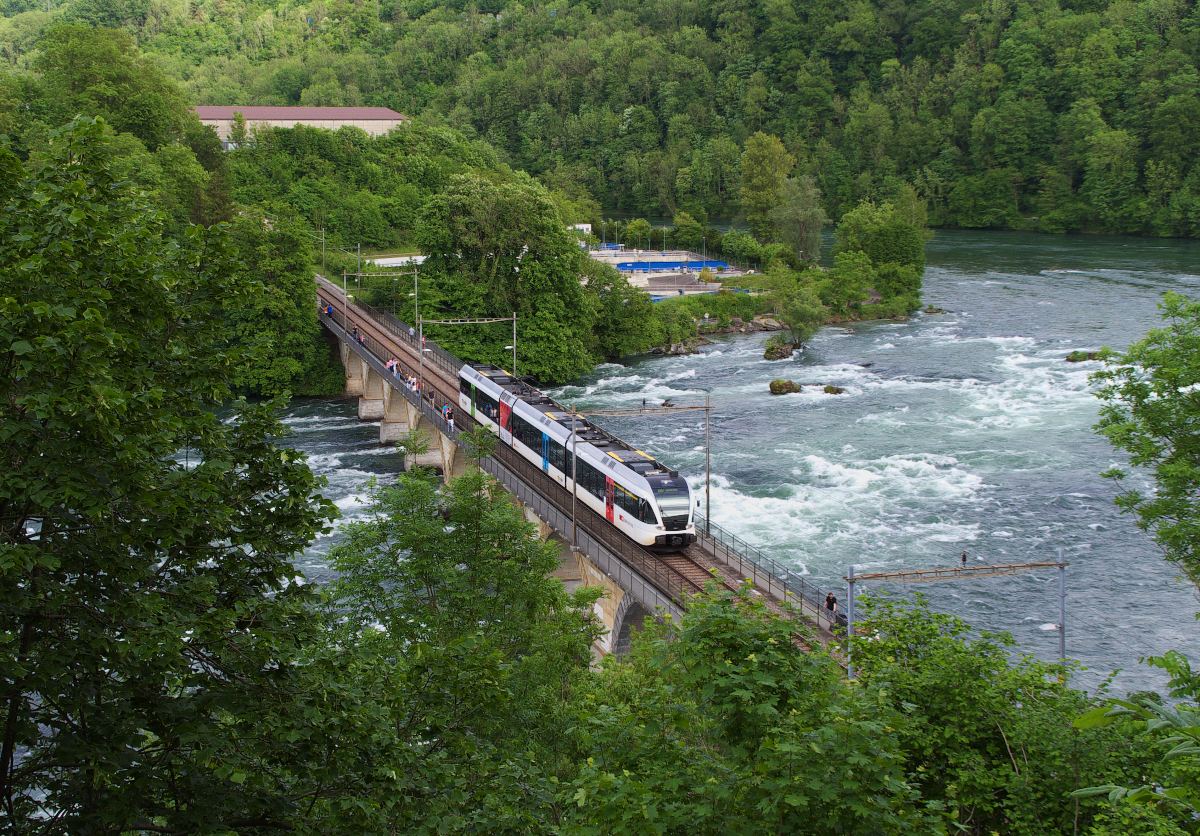 Kein Reinfall.......war weder die Fahrt mit den Triebwagen der THURBO AG, noch der Blick auf die Rheinfallbrücke der Bahnstrecke Winterthur - Schaffhausen. Ich war zu einer Buchpräsentation nach Winterthur eingeladen und mein Schatzi und ich machten auf dem Rückweg von Winterthur nach Singen (Hohentwiel) noch einen Abstecher zum Rheinfall. Ein (Thurbo) Stadler GTW 2/8 ist als S33 von Schaffhausen nach Winterthur unterwegs. 14.05.2015 SBB Kursbuchstrecke 762 - Rheinfallbahn