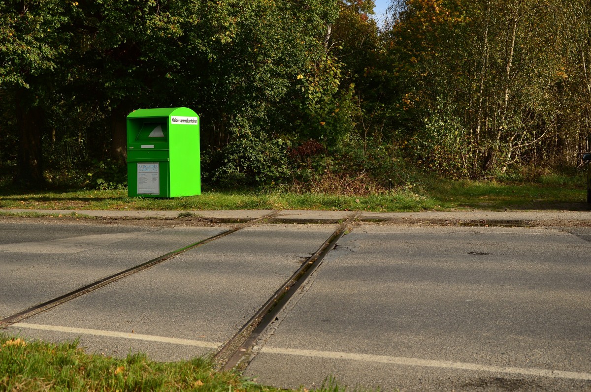 Keine Angst, es geht nicht um den Kleidercontainer. Sondern um die Schienenreste vom Bahnübergang am Kirchberger Bahnhof. Diese gehören zu der Jülicher Kreisbahn die hier früher fuhr. 26.10.2014