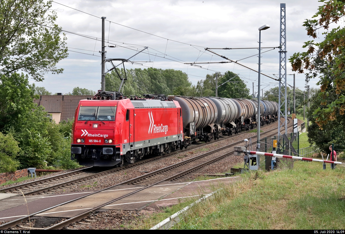 Kesselzug mit 185 584-0 (2052) der RheinCargo GmbH & Co. KG passiert die Anrufschranke in Zscherben, Angersdorfer Straße, auf der Bahnstrecke Halle–Hann. Münden (KBS 590) Richtung Teutschenthal.
[5.7.2020 | 14:09 Uhr]