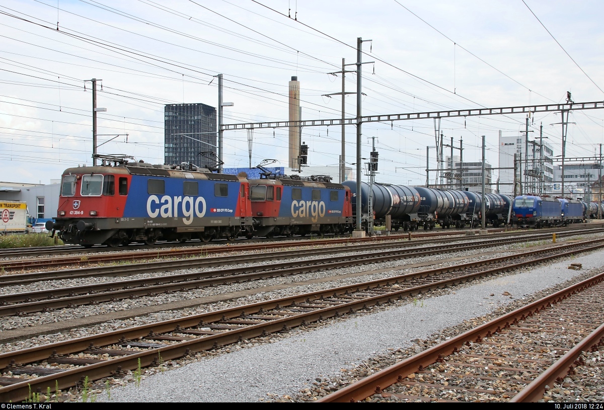 Kesselzug mit Re 4/4 II (421 384-9 und 421 385-6) der SBB Cargo durchfährt den Bahnhof Pratteln (CH) in westlicher Richtung.
Aufgenommen von der Güterstrasse.
[10.7.2018 | 12:24 Uhr]