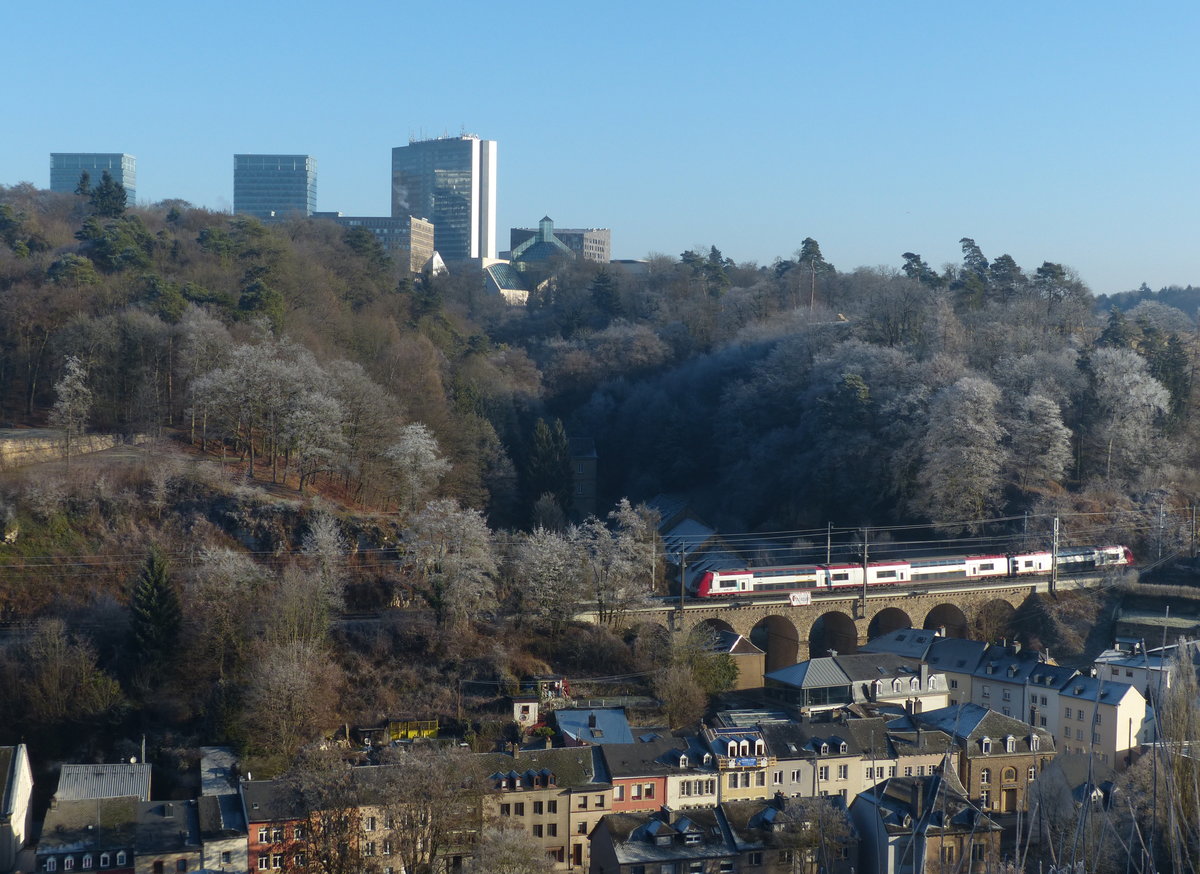 Klirrende Kälte in Luxemburg, aber der Zugverkehr läuft wie geschmiert. Hier überquert eine  Computermaus  der Reihe 2200 das Viadukt über der Rue des Trois Glands. Im Hintergrund die Hochhäuser des Stadteils Kirchberg, der viele EU-Institutionen beherbergt. 30.12.2016, Luxemburg Stadt