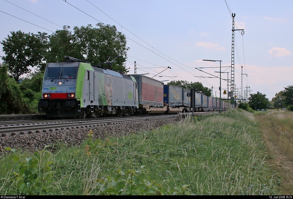 KLV-Zug mit Re 486 503 der BLS Cargo AG durchfährt den Haltepunkt Auggen auf der Bahnstrecke Mannheim–Basel (Rheintalbahn | KBS 703) Richtung Freiburg im Breisgau.
Aufgenommen im Gegenlicht.
[13.7.2018 | 15:13 Uhr]