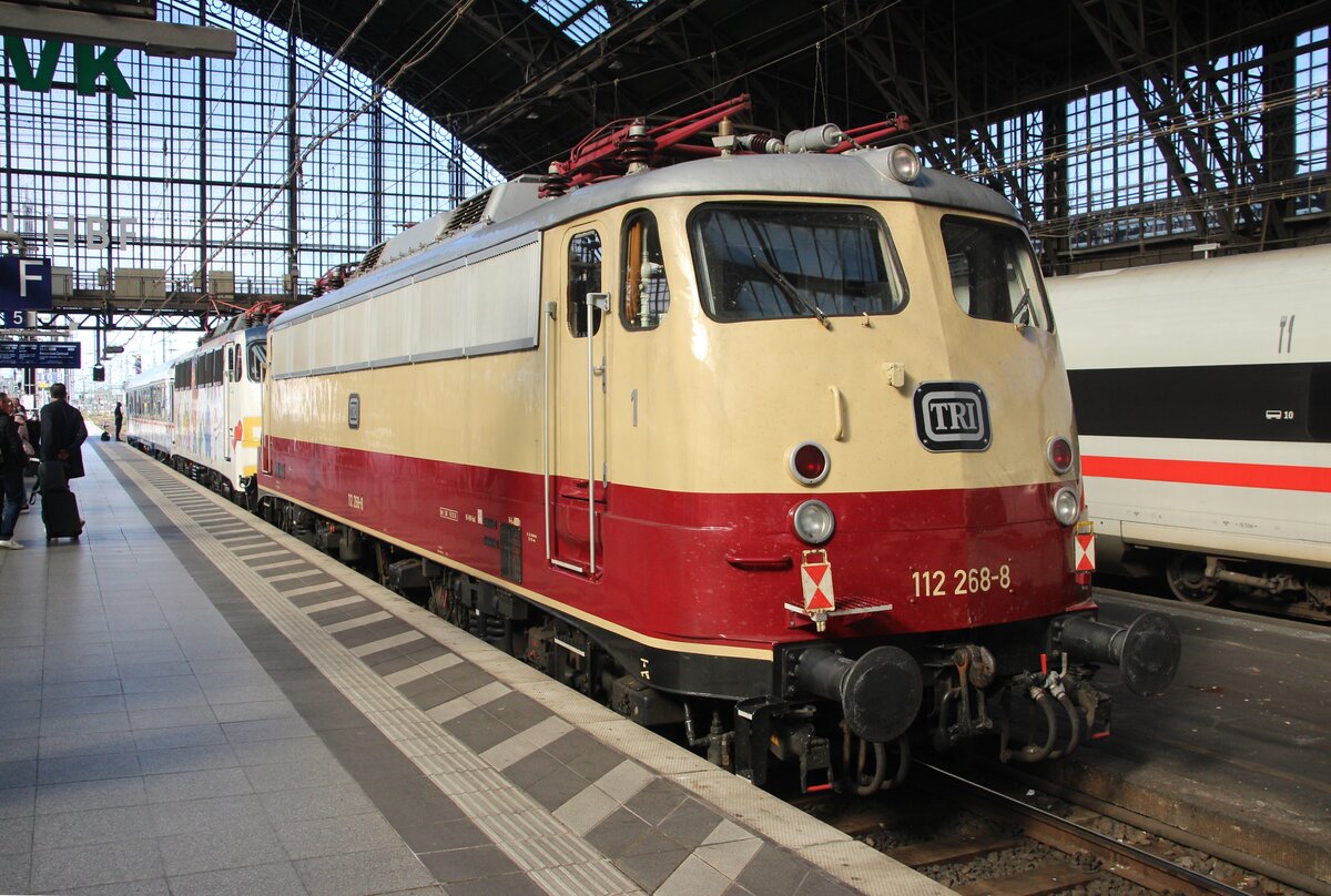 Köln Hbf, Gleis 5 am 02.10.2025: Die kalt mitlaufende und mit Zugschlussschildern versehene 112 268-8 der TRI im Schlepp der Elefanten-Lok 110 469-4, welche einen Steuerwagen in Richtung Bbf schiebt.