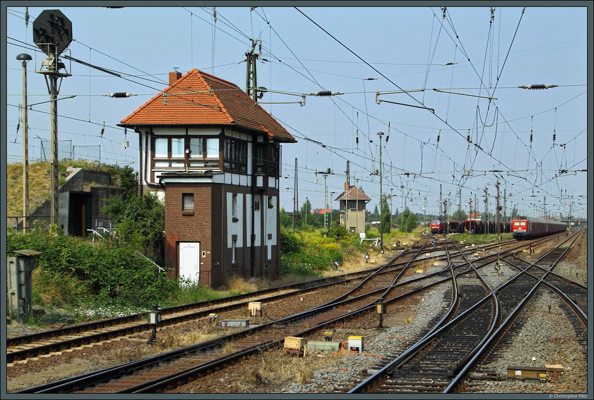 Köthen vor dem großen Umbau (VI): Am südlichen Bahnhofsende des Rangierbahnhofs befindet sich das elektromechanische Stellwerk B6. Links daneben ein Abdrücksignal des stillgelegten Ablaufberges. Im Hintergrund ist das ebenfalls außer Betrieb befindliche Stellwerk R5 zu erkennen. (13.08.2015)