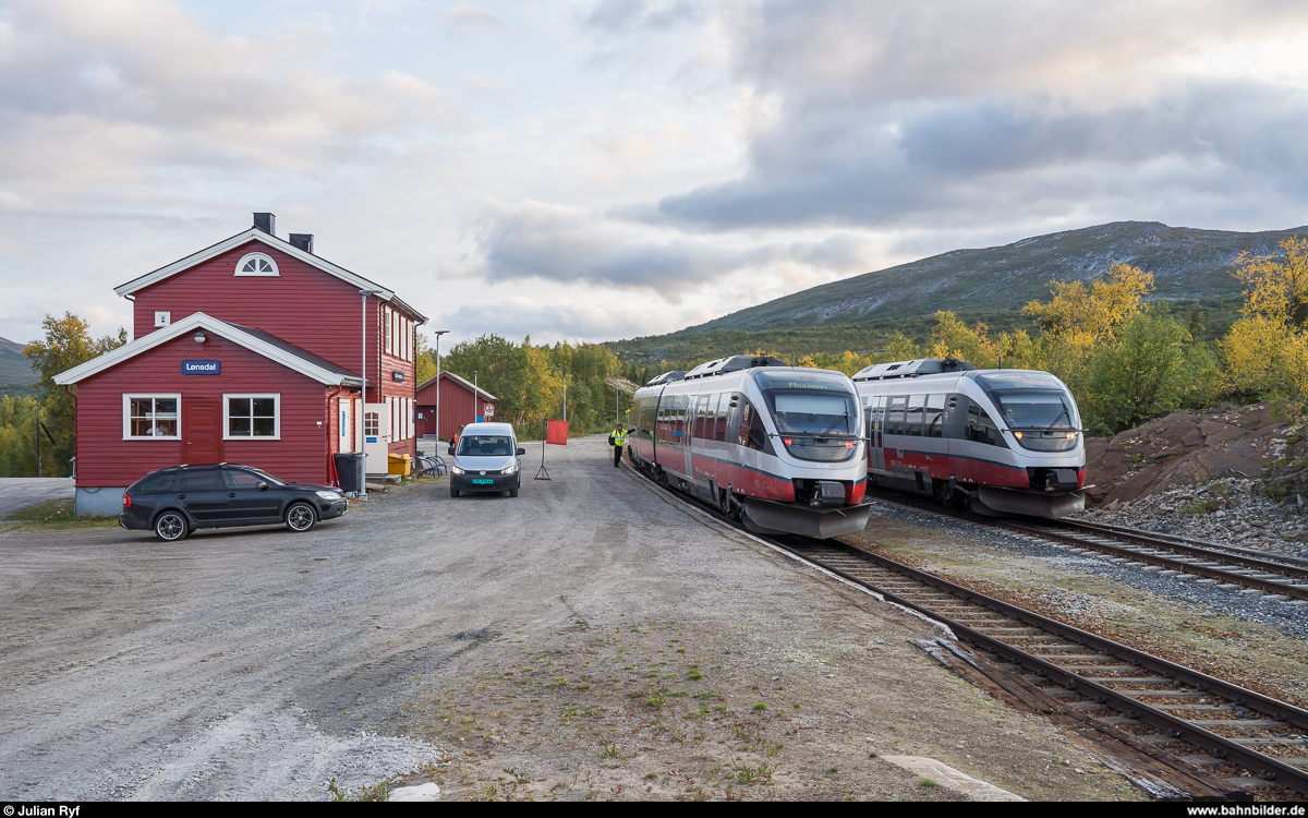 Kreuzung im Bahnhof Lønsdal am Abend des 2. Septembers 2019 zwischen dem BM 93 08 als Regiontog Bodø - Mosjøen und dem zuerst BM 93 05 in der Gegenrichtung. <br>
Da der Bahnhof Lønsdal nur über ein Perrongleis verfügt, muss der südwärts fahrende Zug vor der Einfahrweiche jeweils den Fahrgastwechsel des Nordfahrers abwarten, welcher danach auf das perronlose Gleis umgestellt wird. Die Handweichen werden vom Bahnhofsvorstand bedient, welcher die Distanz zwischen den beiden Einfahrweichen mit dem Dienstwagen zurücklegt.
Der Bahnhof Lønsdal verfügt trotz seiner abgeschiedenen Lage über einen Bahnhofsvorstand und einen geheizten Wartsaal.